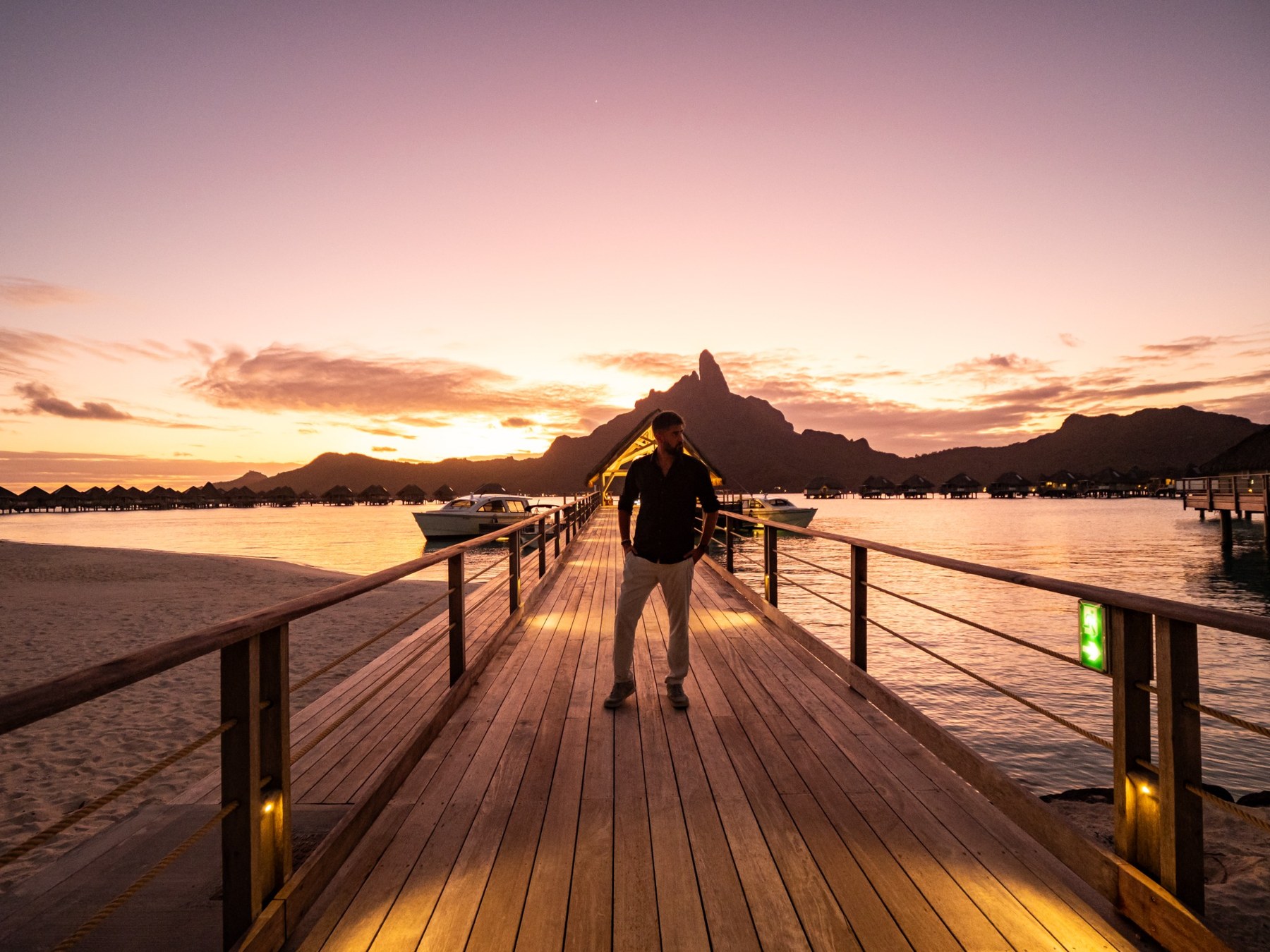 Alex Black sur un ponton à Bora Bora au coucher du soleil