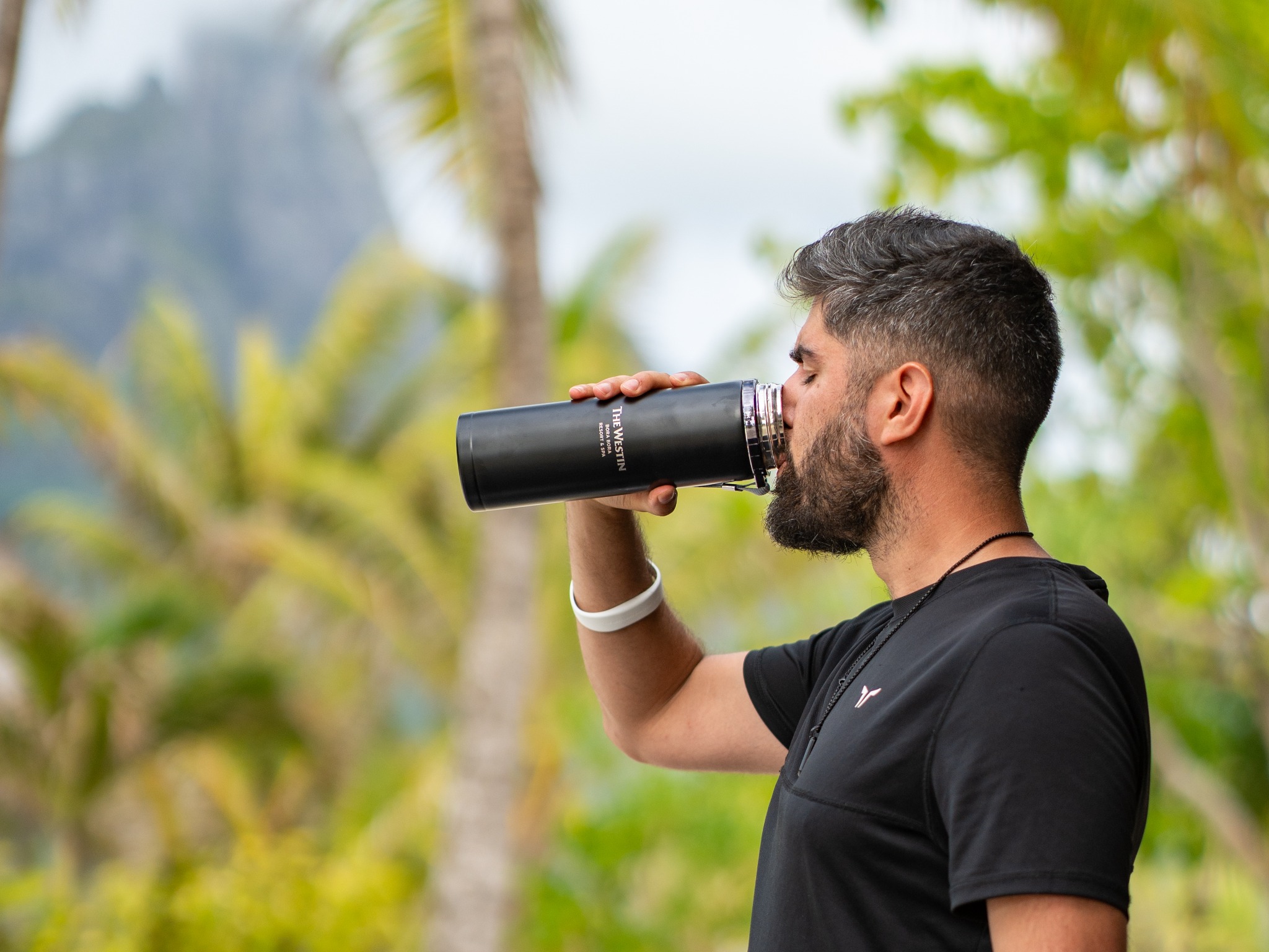 Alex Black drinking from a Westin bottle in Bora Bora