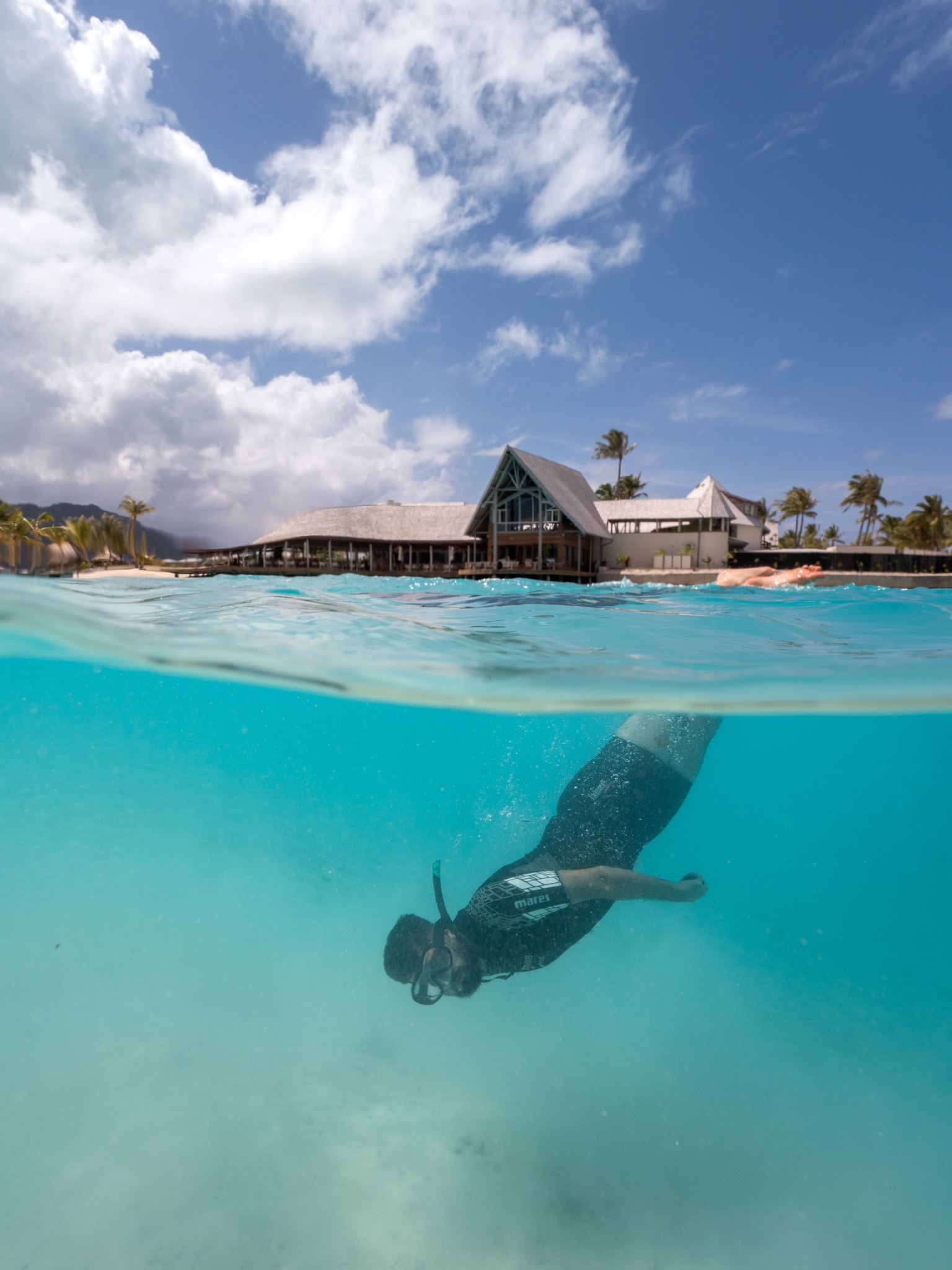 Bora Bora lagoon with swimmer underwater